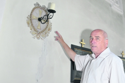 Pfarrer Josef Wörter zeigt einen der Mauer-risse im Inneren der Kirche.