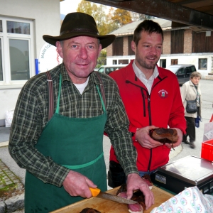 Obmann vom Verein „Bauernmarkt Brixlegg“ Georg Moser mit Sohn Peter am stark frequentierten Speckstand