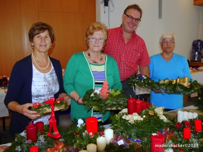 Bez-Obmann Otto Mühlegger begutachtet mit drei Damen aus seiner fleißigen Bastelgruppe die dekorativen Weihnachtsgestecke und Kränze