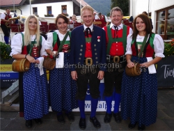 Kapellmeister Peter Steinbacher und Obmann Josef Kirchler mit feschen Marketenderinnen der BMK Angath