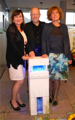 LRin Mag. Dr. Beate Palfrader, Künstler Prof. Mag. Helmut Nindl, Kunsthistorikerin Dr. Maria Schuchter mit dem Ausstellungsstück „Kubus-Stele weiss“ aus Betonguss weiss, Floatglas und LED-Installation