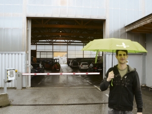 Brixleggs Umweltberater Florian Jeram mit seinem "Ich war mal eine PET-Flasche"- Regenschirm vor der Einfahrt des AMU-Recyclinghofes Kramsach.