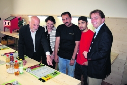 Werkstättenmeister Armin Wechselberger erklärt Schmuckdesignerin Margit Schüsler, den mithelfenden Asylwerbern Yasir und Mohammad und LA VBgm. Martin Wex einen der Do-It-Yourself-Arbeitsplätze (v.l.).